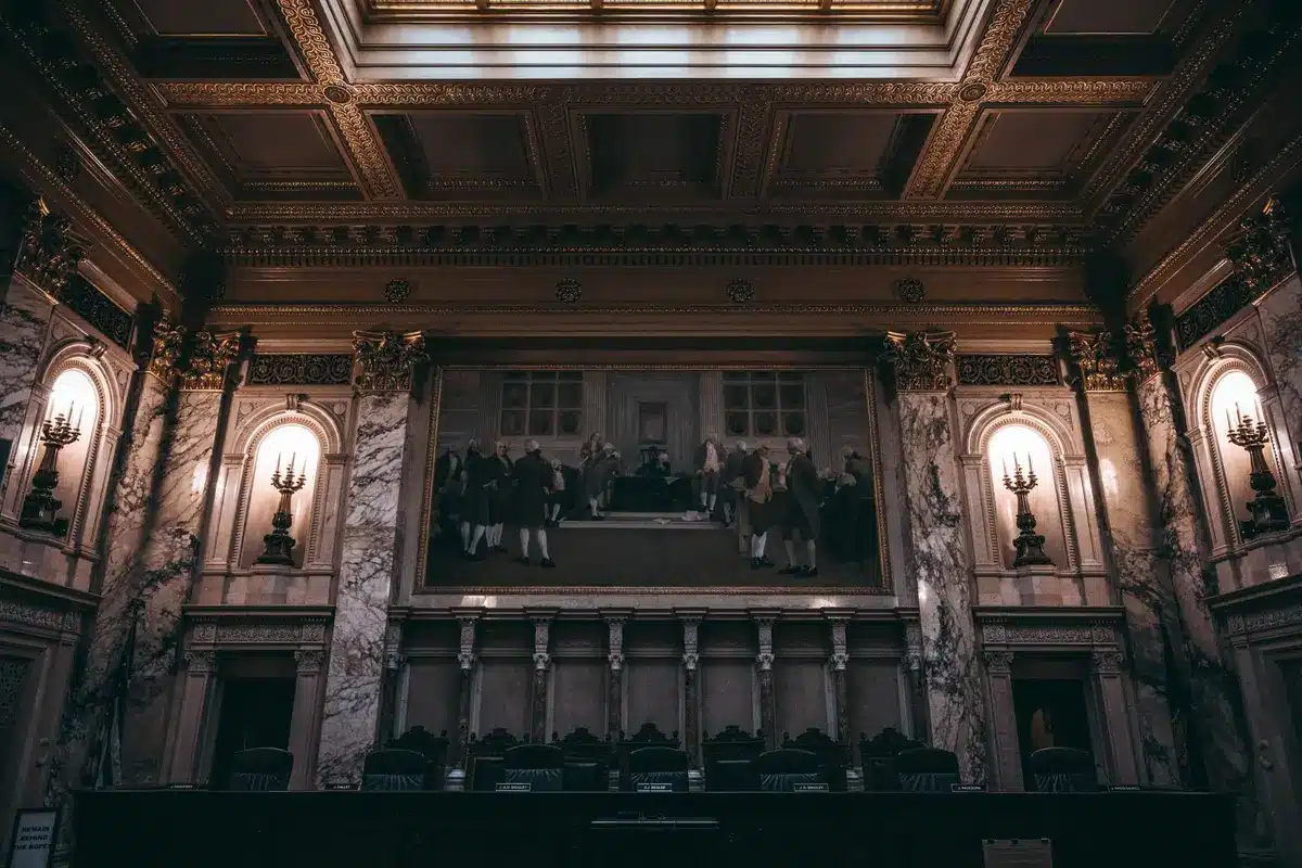 An empty congressional chamber with sunlight streaming through tall windows, a single podium standing alone on the floor, shadows stretching across marble columns, symbolizing the separation of religious and political power.