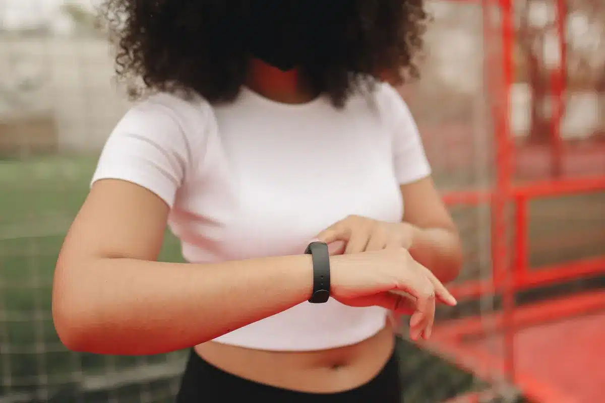 An ankle monitor close-up on a person's leg, with a blurred background of a home interior, symbolizing surveillance and restricted movement.