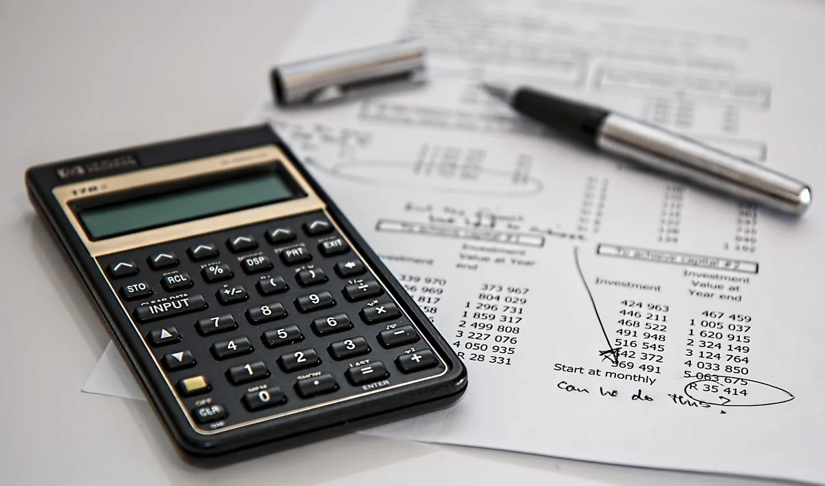 A modern state government building interior with financial documents and ledgers visible on a desk, representing fiscal oversight and state treasury management