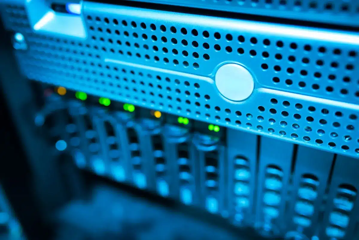 A data center floor filled with rows of GPU servers under cool white lighting, racks of computing equipment extending into the distance, cables neatly organized overhead, a sense of industrial scale and precision engineering.
