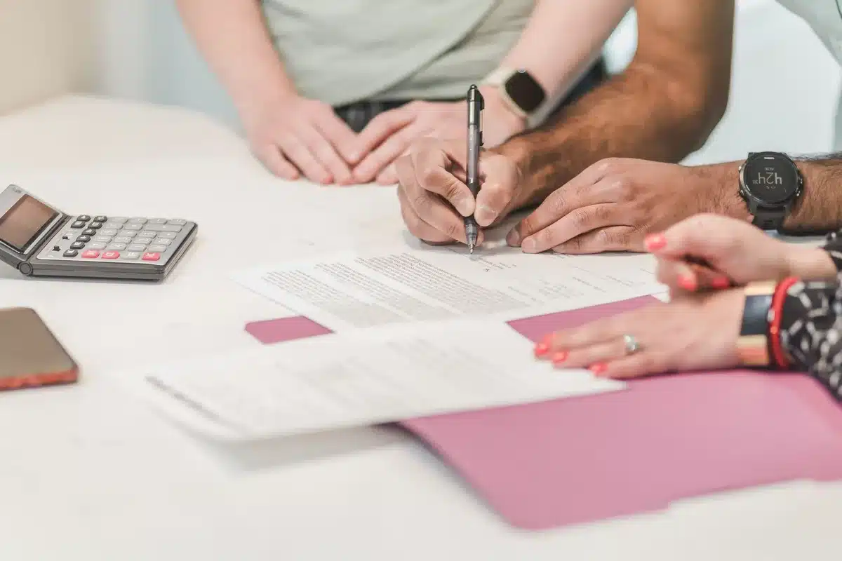 Healthcare documents and insurance paperwork spread on desk, cost-related charts visible, professional office setting with soft lighting