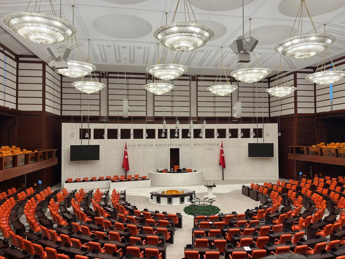 Two politicians in separate frames, one at a podium in a legislative chamber, the other in an executive setting, both in neutral professional poses
