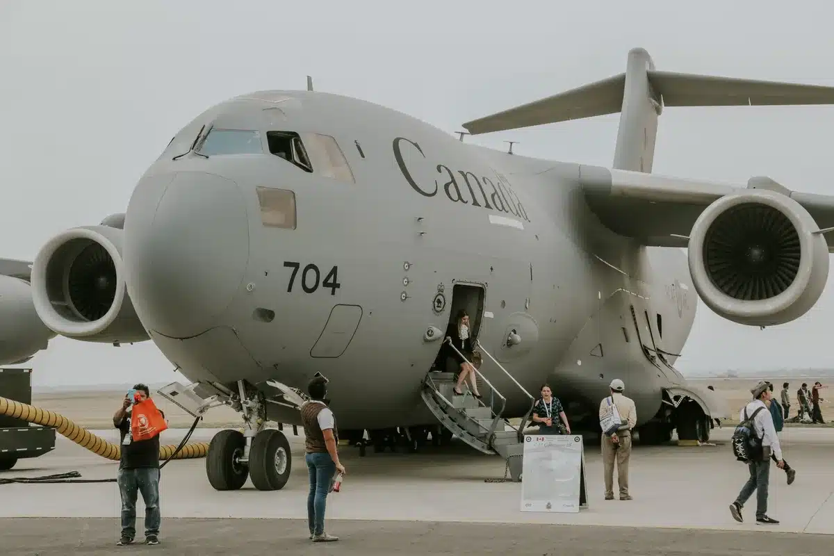 A C-17 Globemaster cargo aircraft on an airfield tarmac, military insignia visible on fuselage