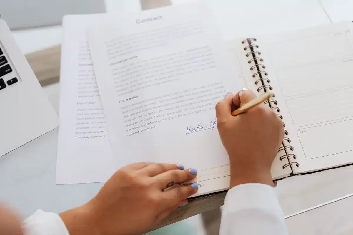 A stack of legal documents and case files on a desk with a gavel nearby, soft office lighting, papers slightly disheveled suggesting ongoing work and pressure, neutral institutional setting