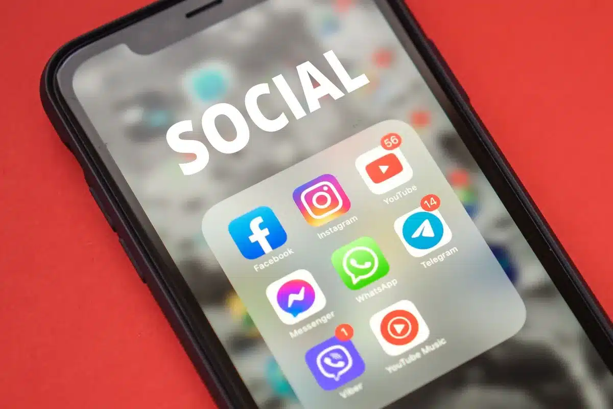 Split-screen composition showing contrasting social media reactions&mdash;left side showing angry emoji reactions and harsh comments, right side showing supportive messages and celebration emojis, bright and dim lighting respectively