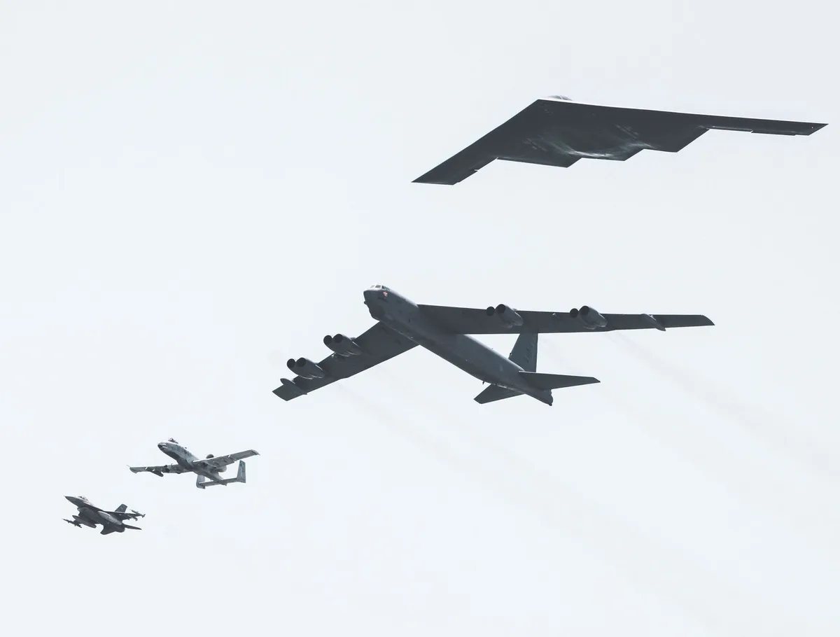 Unmanned tactical aircraft in formation flight, sleek and stealthy design, banking through clouds, no pilot visible