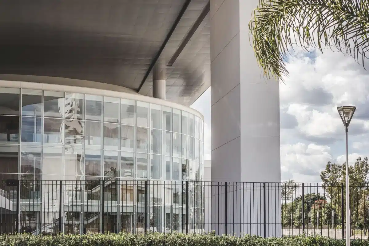 Kennedy Center marble facade with white protective tarps covering the section where a name once appeared, scaffolding visible, the iconic building's architecture partially obscured