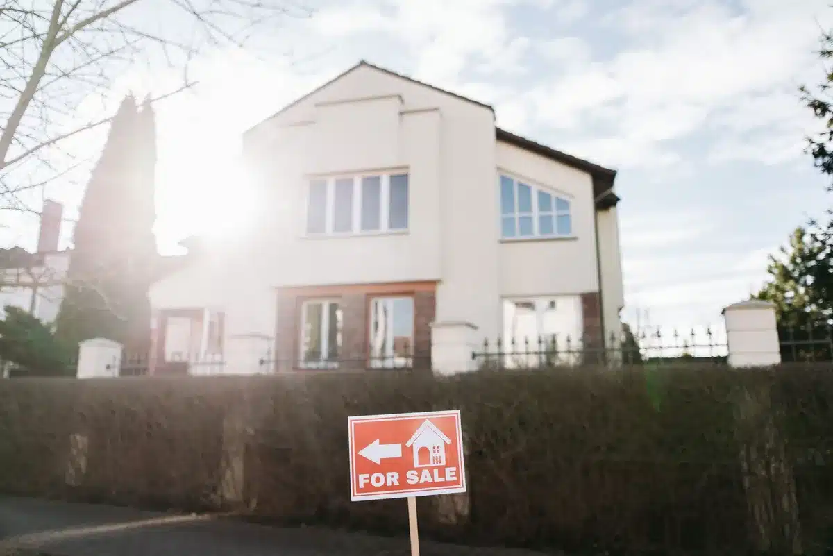 Two campaign signs side by side on a suburban street, one for an independent candidate, one for a democratic candidate, morning light, a voter walking past with a ballot in hand, representing the choice ahead
