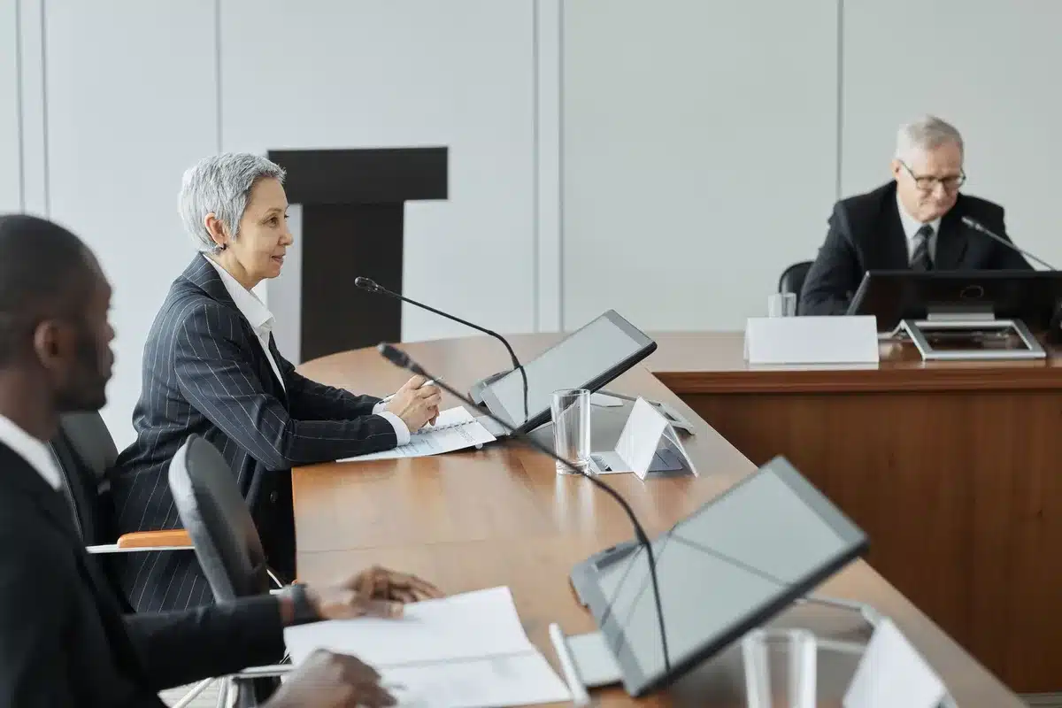 A long conference table with empty chairs in a dimly lit room, papers and documents scattered, a single microphone in focus, suggesting negotiations at an impasse.