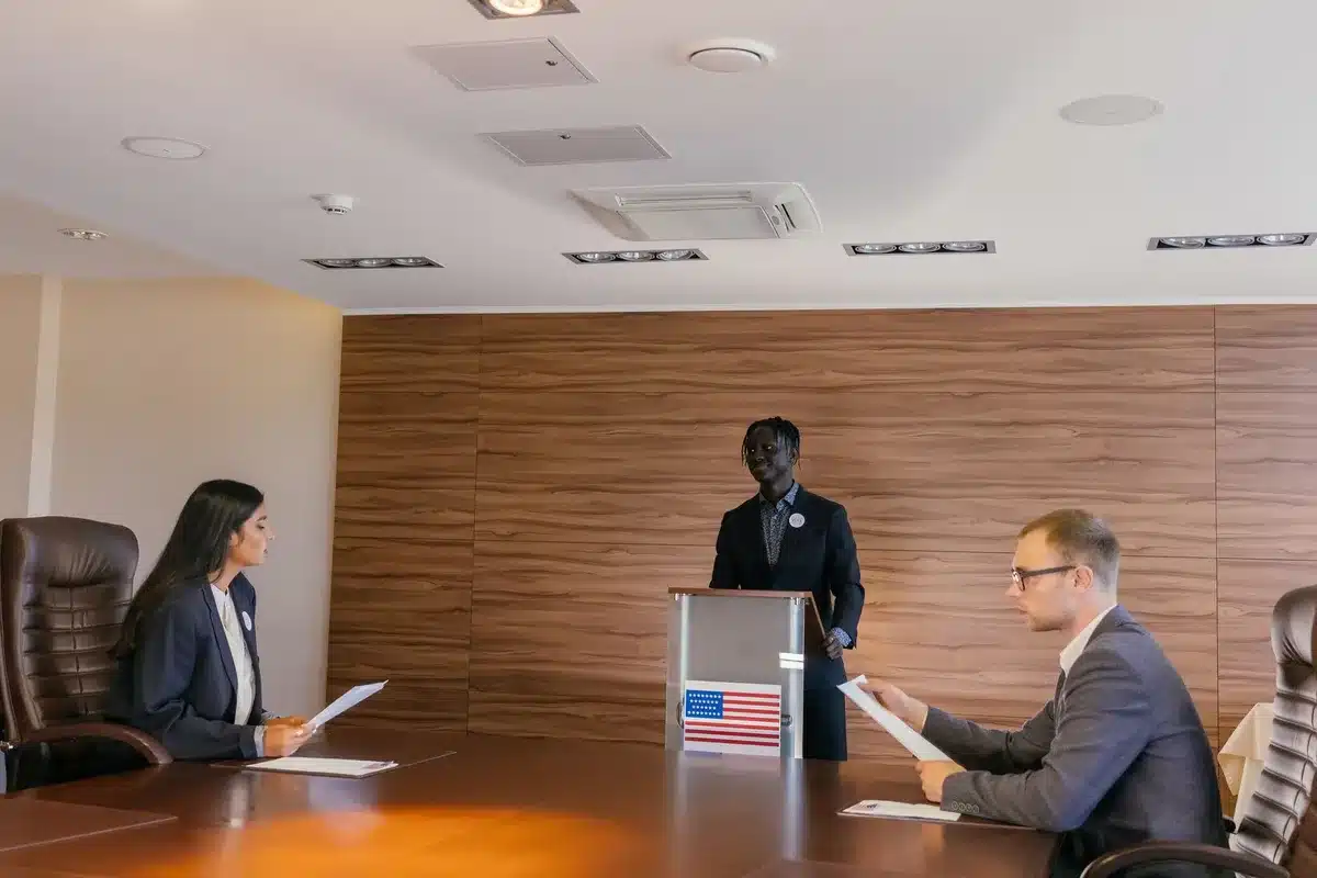 Official government boardroom with maps of Great Lakes region on walls, empty chairs around conference table, formal treaty documents stacked on mahogany desk