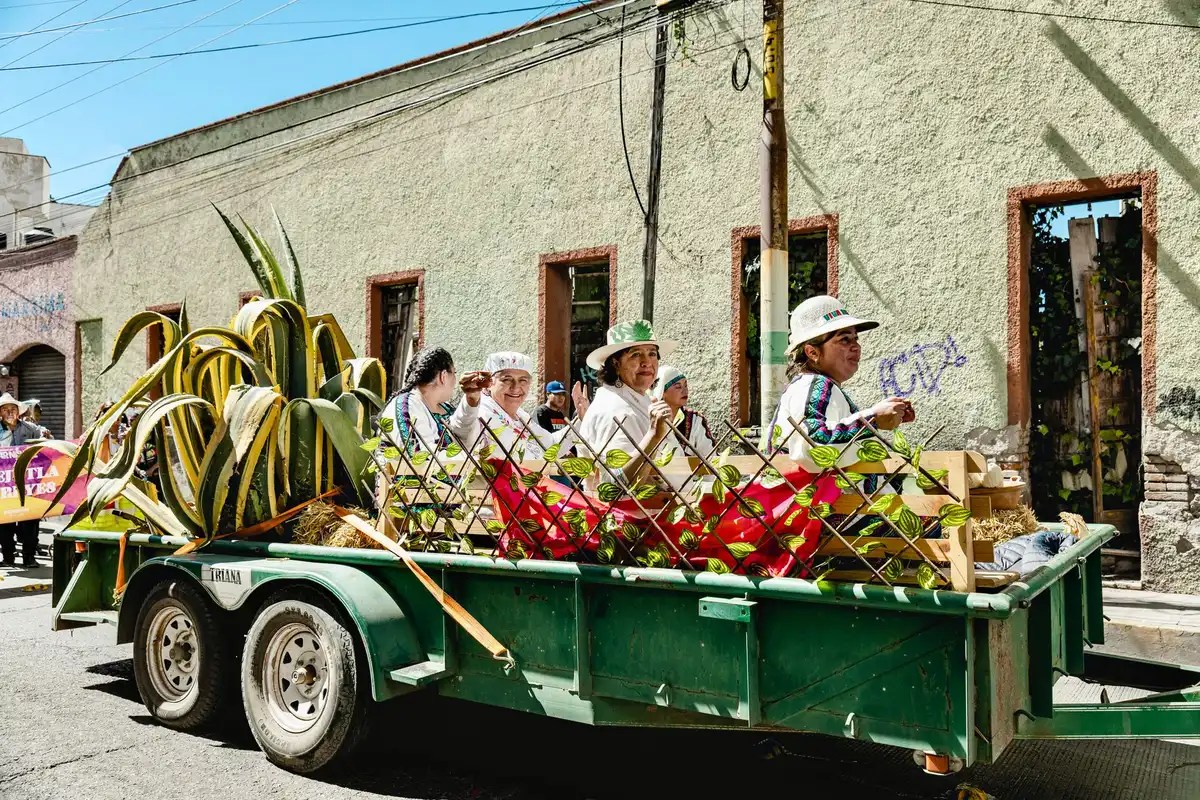 parade float with campaign signage and spectators lining the route, colorful banners and candidate branding visible from the float, daytime outdoor setting