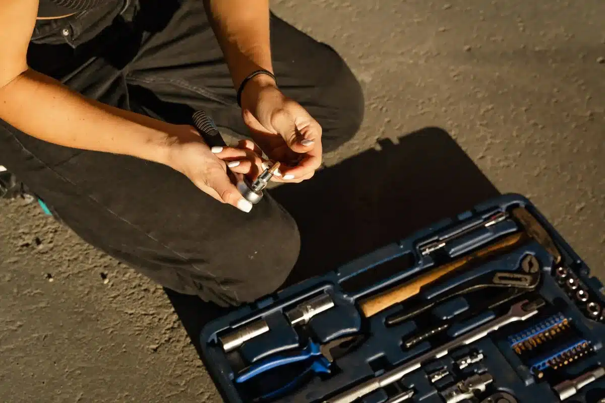 Rows of freshly repaired playground swings and seesaws glistening in afternoon sun, with paint cans and repair tools staged nearby on the ground, park benches in soft focus behind