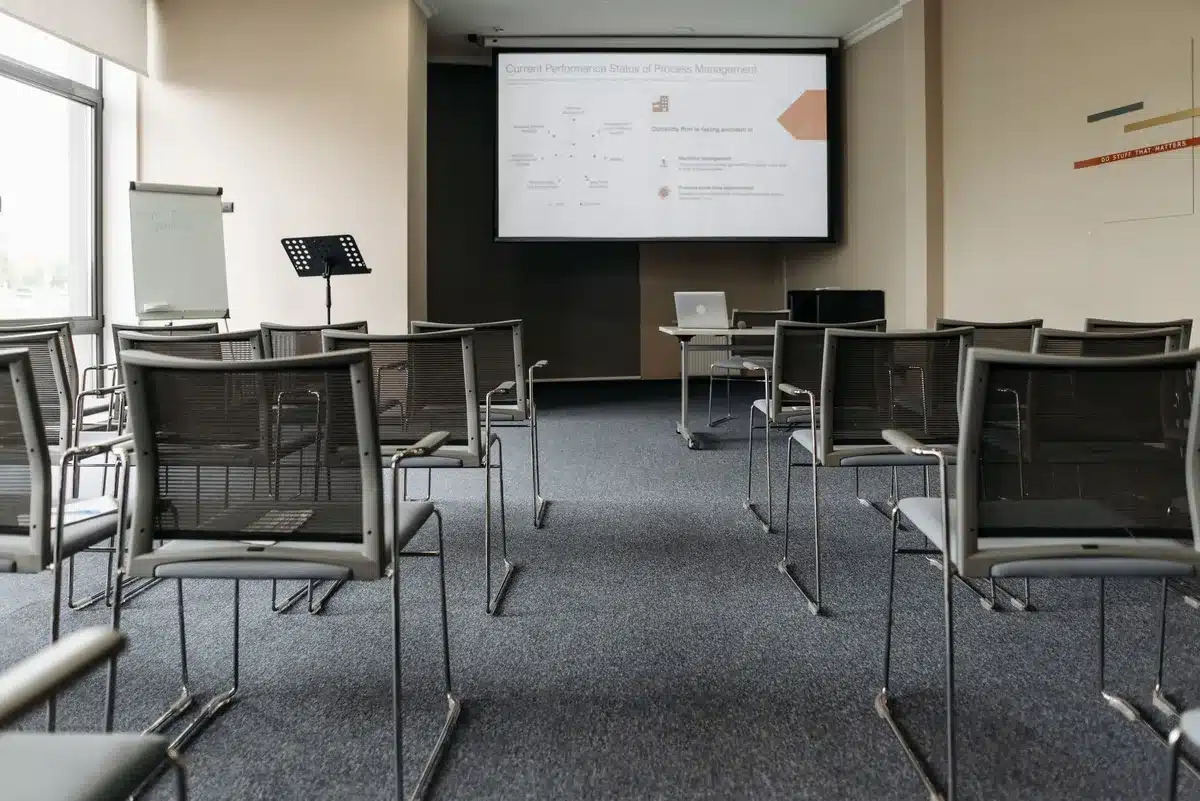 A conference room with empty chairs and a closed door, suggesting organizational transition