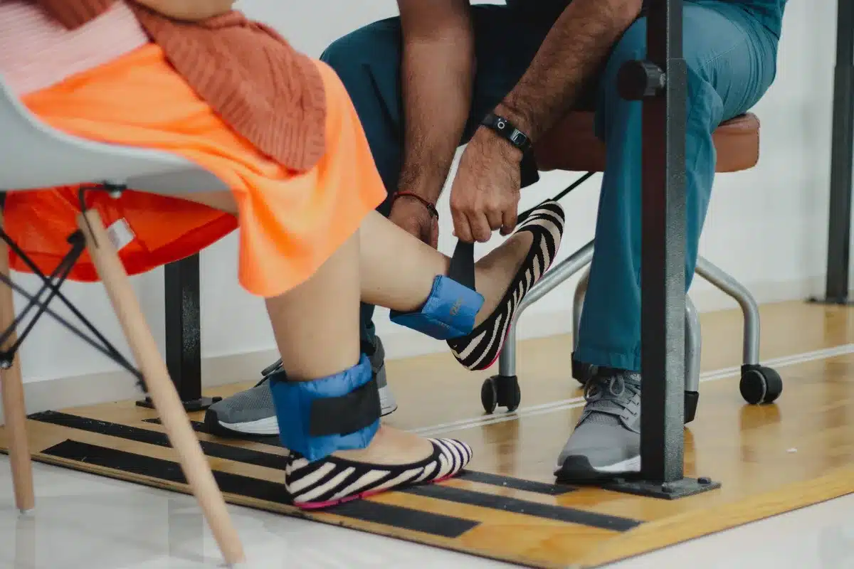 An elderly man's weathered hands gripping parallel bars during physical therapy, focused concentration on his face, a therapist's hands nearby offering support, soft institutional lighting