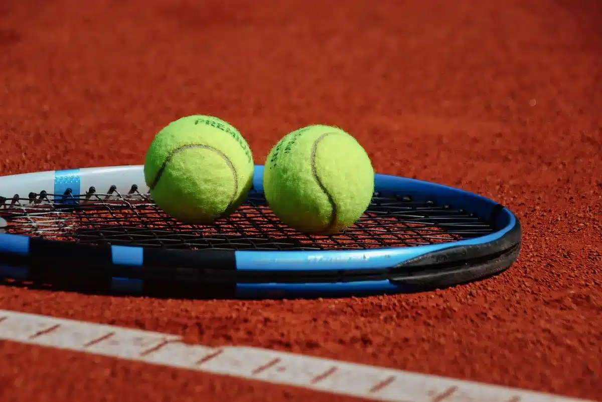 Professional tennis player in mid-serve on a hard court during a Grand Slam tournament, intense focus visible, stadium lights reflecting off the court surface