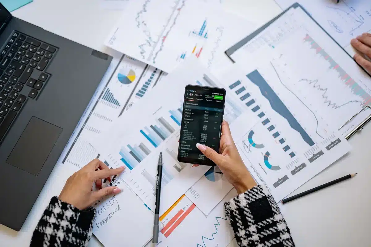 Financial analyst monitoring earnings data on a glowing screen in dim office lighting, charts and numbers visible