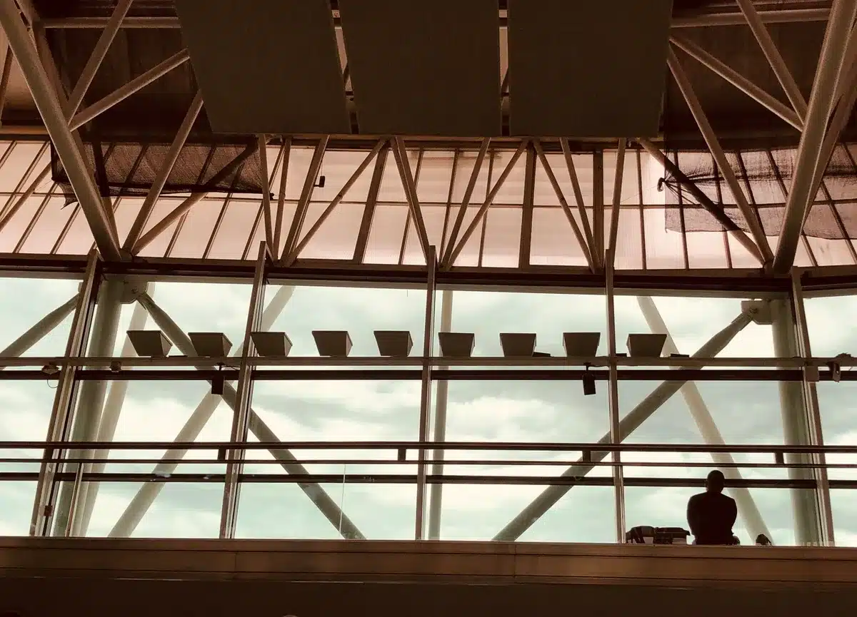 Modern airport terminal security checkpoint with integrated air cleaning units mounted on walls, subtle technology visible in the architectural design, clean bright lighting, contemporary aesthetic