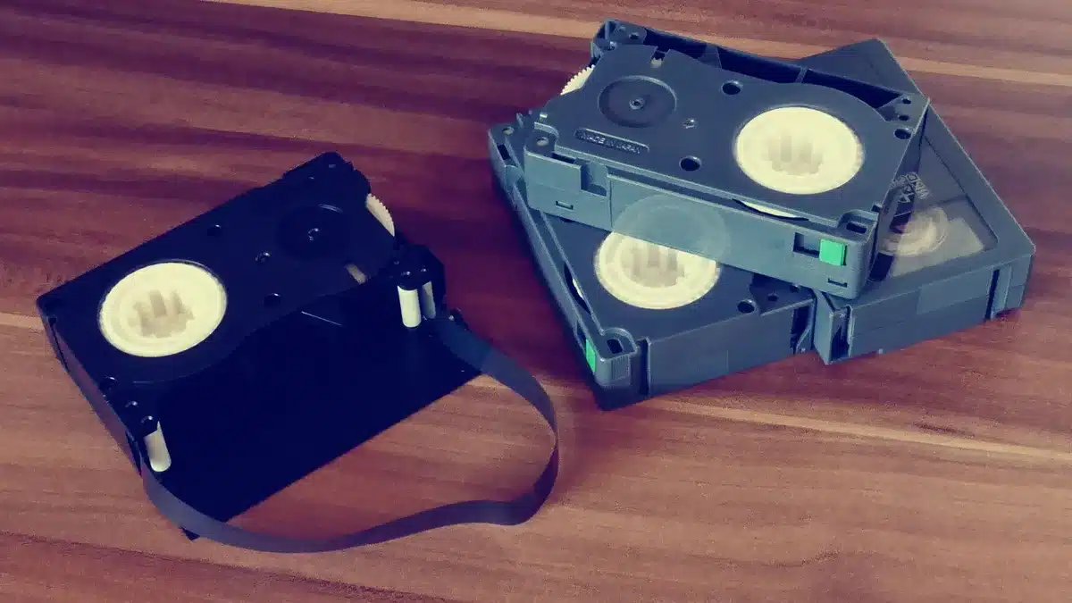 A film production set with archival cameras, reels of film stock, and editing equipment arranged on a studio table, warm lighting highlighting preserved footage materials.