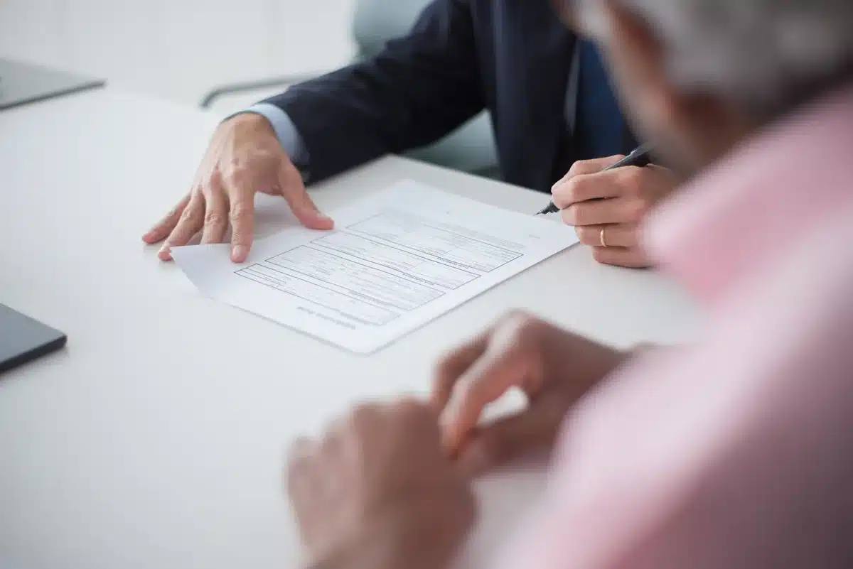 A close-up of a mortgage document with a calculator and pen on a wooden desk, soft natural light casting shadows, suggesting financial planning and calculation