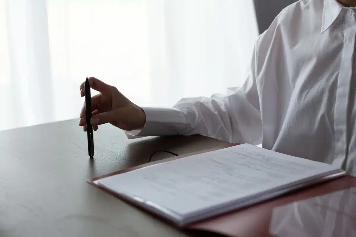 A mortgage application form and house keys on a wooden desk, with a calculator and financial documents, soft natural light