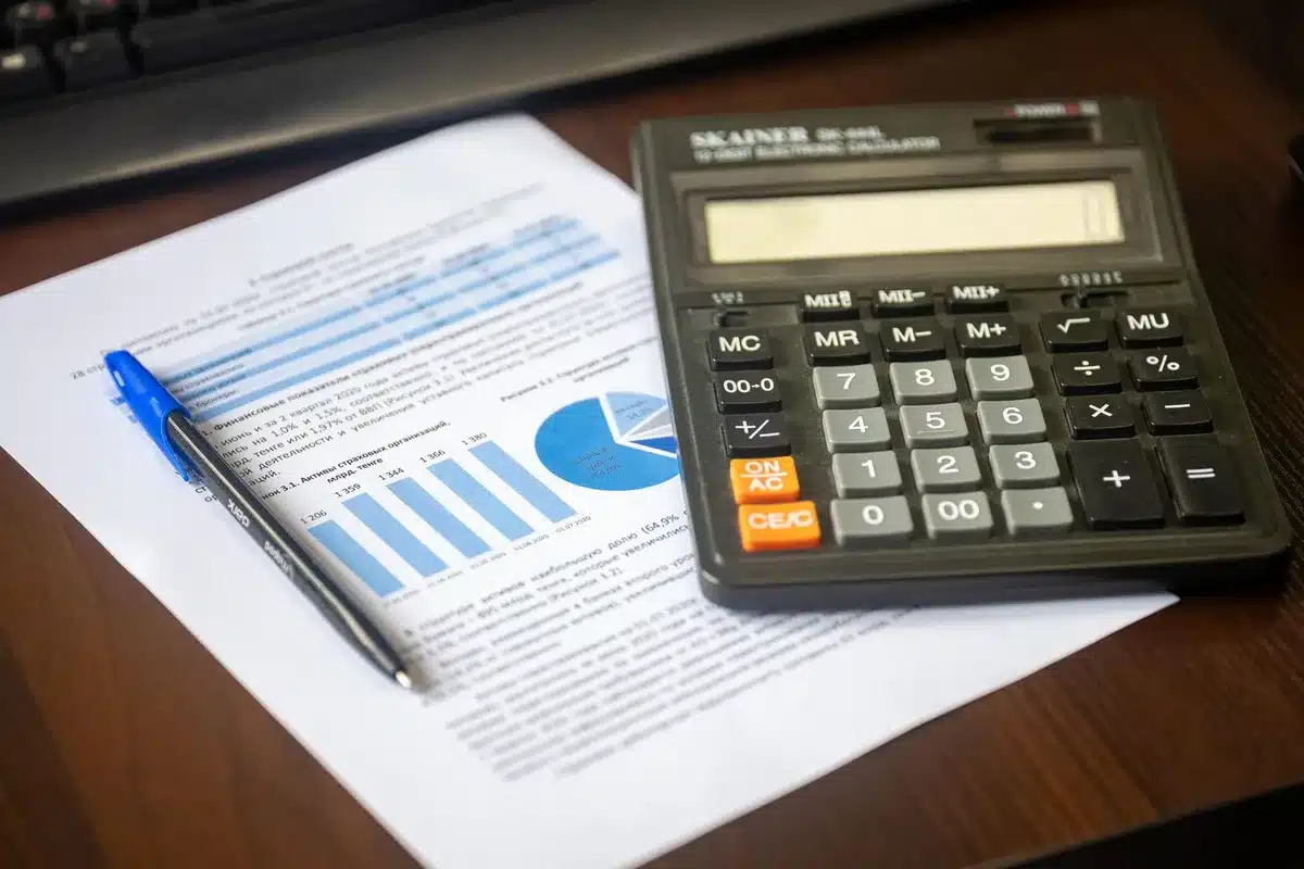 A computer screen displaying a mortgage rate calculator with upward trending arrow chart, blue and green data visualizations, close-up view