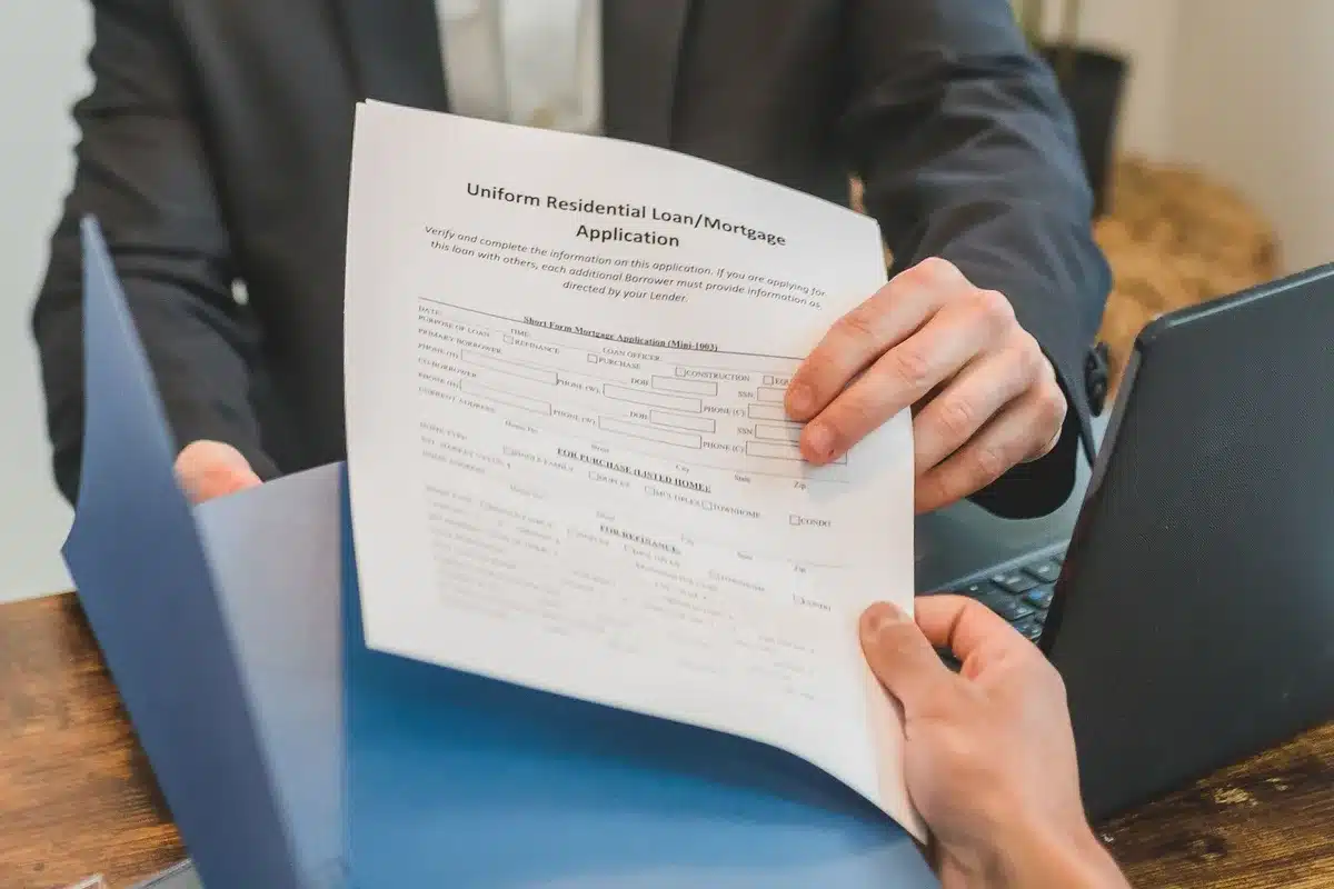 A close-up of a mortgage application form with a pen resting on it, soft warm lighting emphasizing the document details, a calculator partially visible in the background