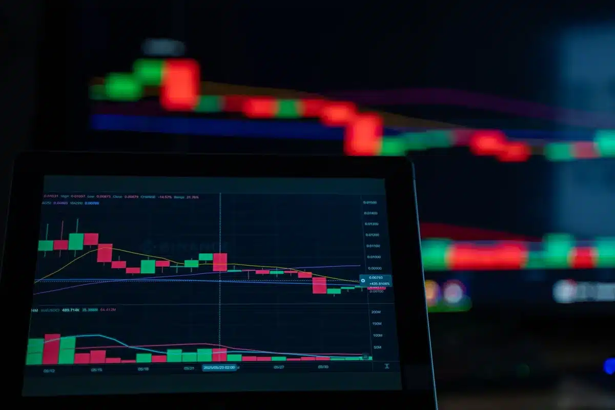 Blurred financial chart on a monitor screen showing interest rate trends climbing upward, with keyboard and mouse in foreground, cool blue tones