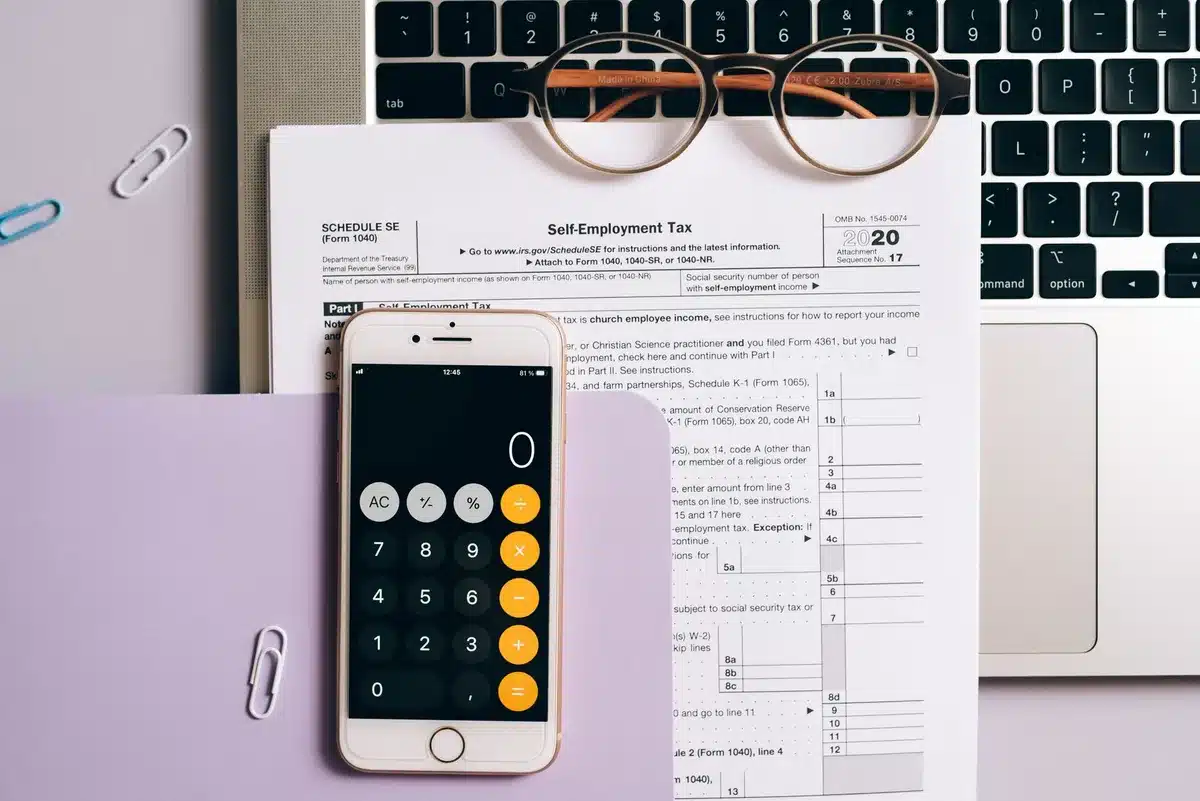 A portfolio statement showing dividend payment dates and amounts, stacked coins representing growing income streams, a calendar marking dividend ex-dates, warm lighting on financial documents
