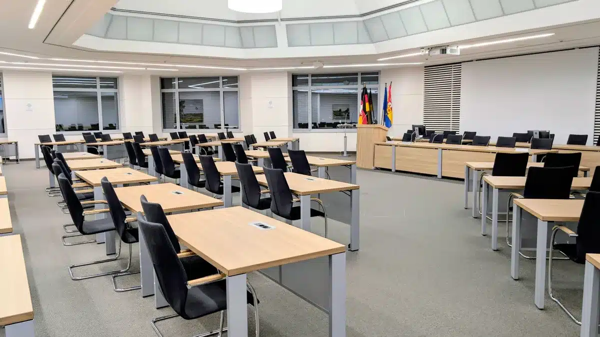 A stern government office interior with an empty podium and American flags, harsh shadows under fluorescent lighting, conveying institutional tension and political pressure
