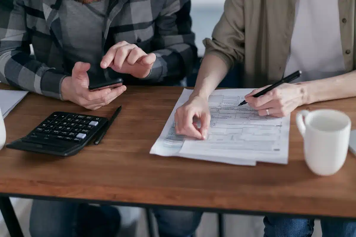 A closeup of a calculator displaying large numerical figures next to documents labeled with budget and spending categories