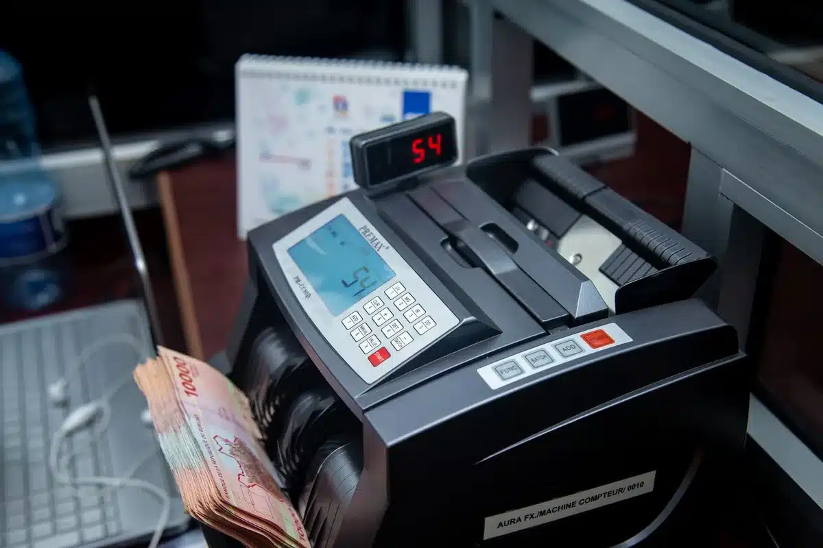 A glowing digital debt counter display showing numbers climbing toward 40 trillion, with financial charts and upward arrows in soft focus behind it