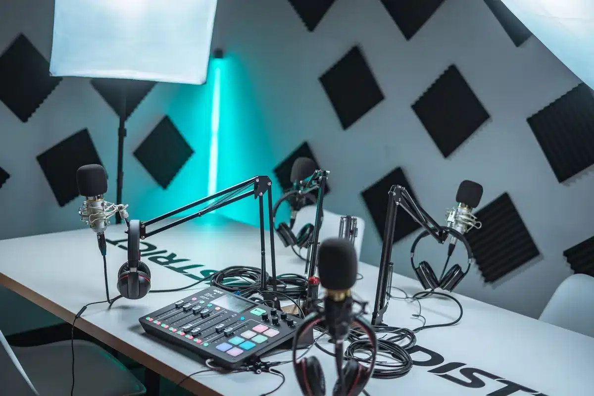 A podcast studio microphone on a stand, dim lighting casting shadows, empty chairs in the background, representing a controversial statement made in a broadcast setting