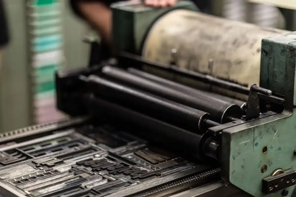 A newspaper printing press in motion, pages flowing through rollers, ink and paper detail, motion blur on the machinery, industrial lighting