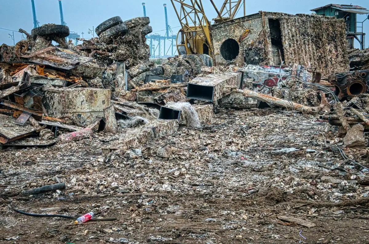 Aerial view of wooden cabana debris strewn across a beach club grounds after a tornado, with intact structures visible in the distance