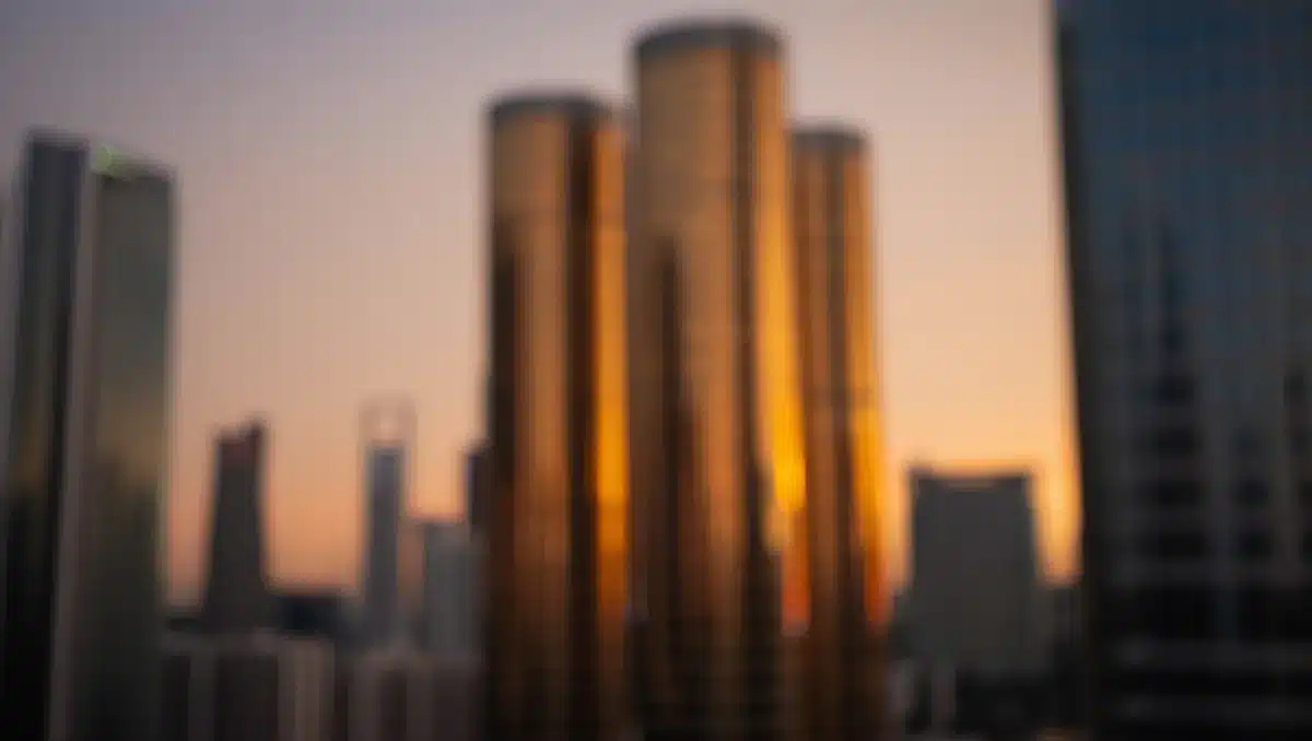 A modern financial district skyline at dusk with glass towers reflecting amber light, representing institutional capital and Wall Street partnership | financial district towers capital markets