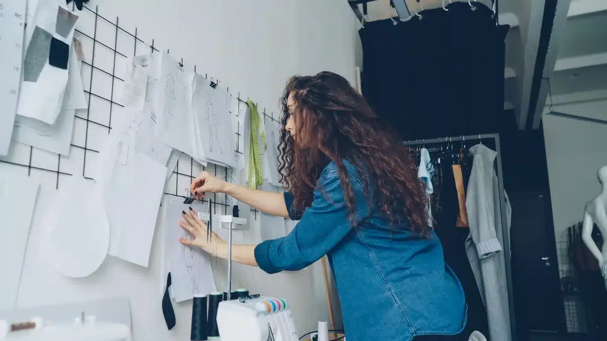 A minimalist design studio workspace with mood boards, typography samples, and food photography pinned to walls, natural light streaming across a wooden desk with design tools and color palettes, creative energy and intentionality