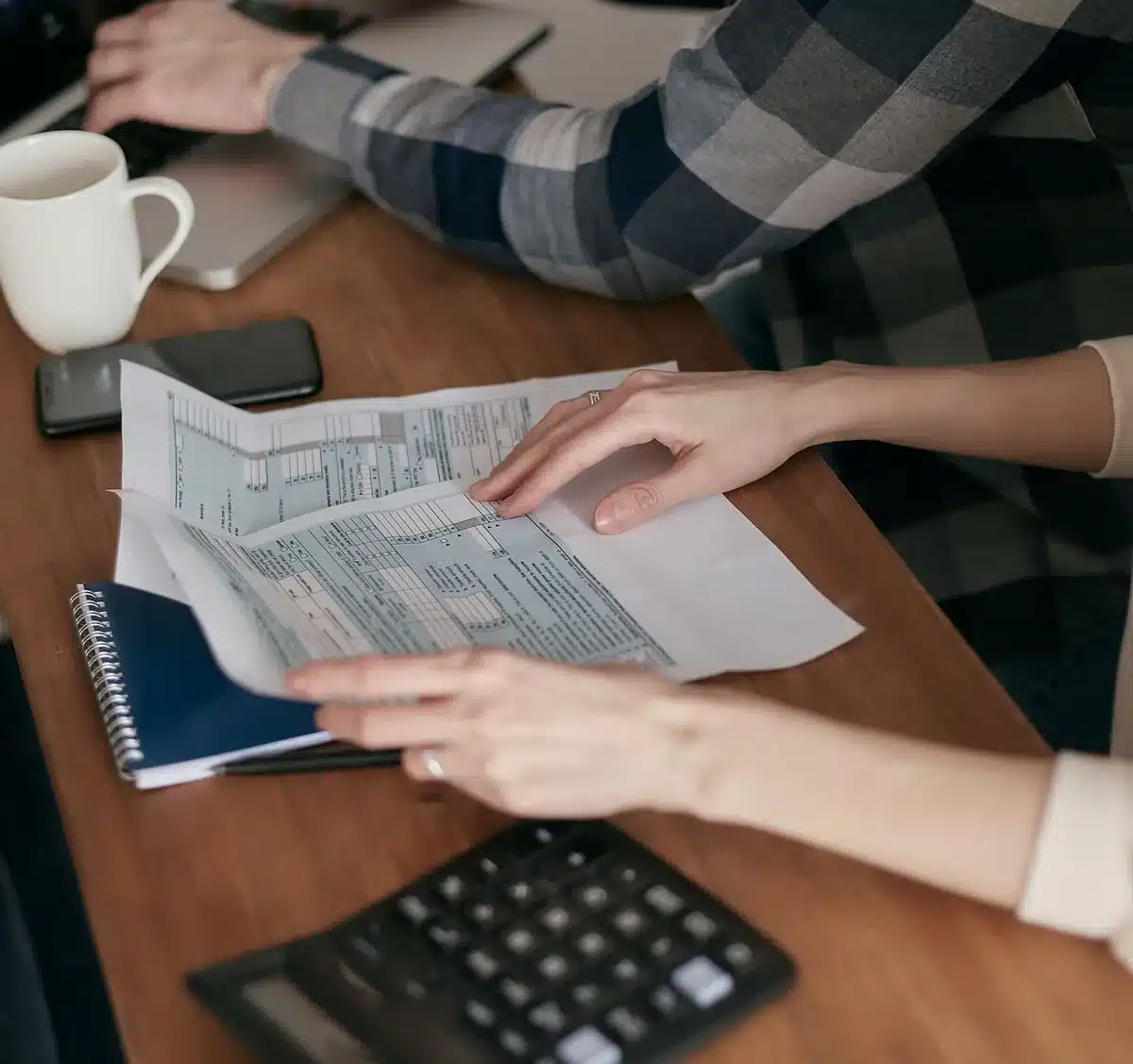 A property tax bill or assessment notice lying on a table with a calculator and pen nearby, symbolizing household financial strain