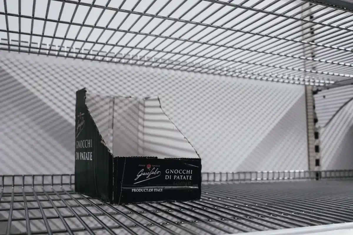 Multiple empty or closing grocery store shelves, checkout areas, or storefront signage, showing the scale of retail transitions, muted lighting, sense of transition or downsizing