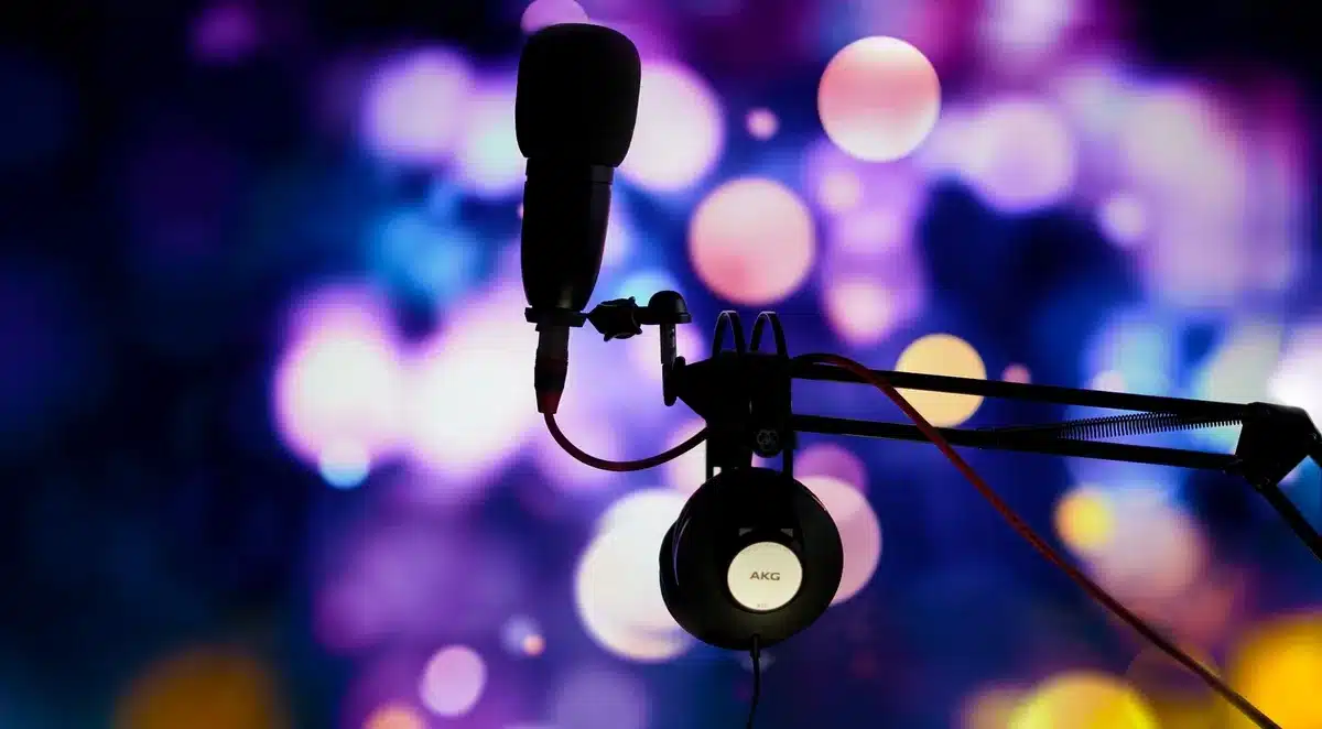A radio broadcast studio microphone and equipment in dim lighting, representing political commentary and discourse