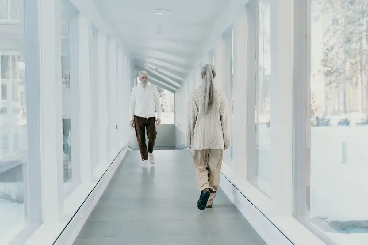 A busy White House hallway with staffers walking past, blurred figures in motion, official portraits on the walls, the atmosphere one of ongoing activity and transition