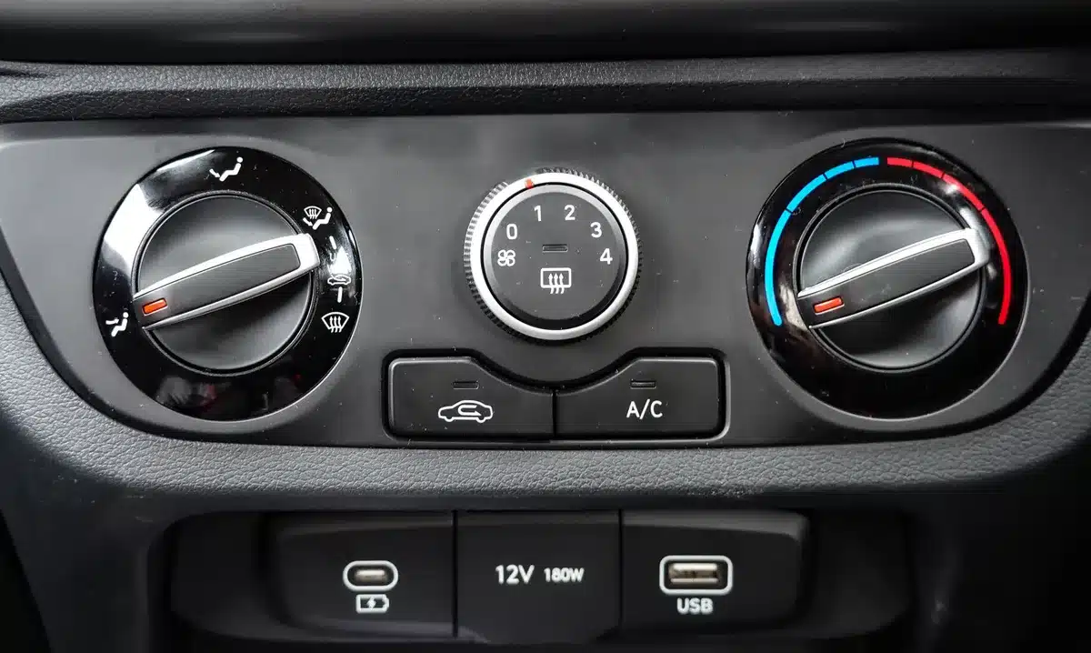 A sleek hybrid sedan's interior dashboard with climate control panel visible, split lighting showing two different temperature zones, modern minimalist design.