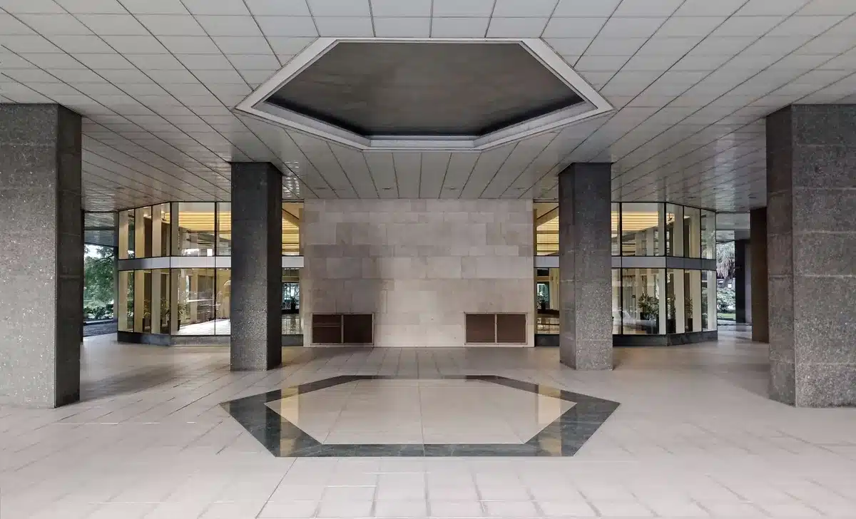 A federal office building corridor with empty desks and dim lighting, symbolizing the removal of civil service protections and federal workforce reductions.