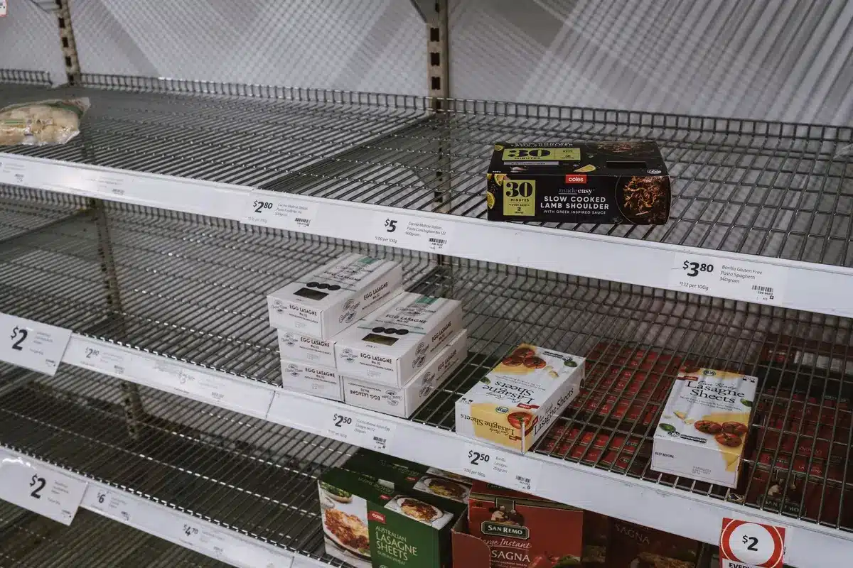 Pastel-colored ice cream pints in monochromatic cardboard packaging, side by side on a retail shelf under bright fluorescent lighting, one labeled with minimalist black script lettering, the other with similar design elements, creating visual confusion.