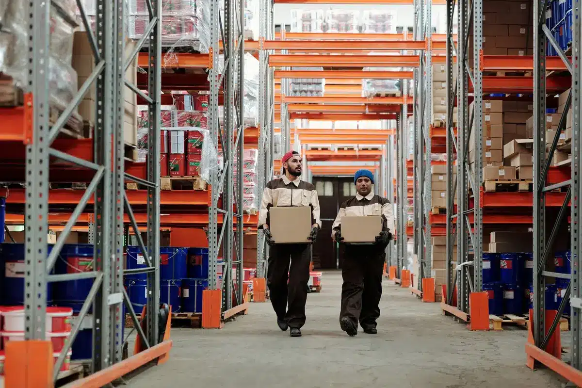Warehouse shelf rows with sparse merchandise, harsh overhead lighting, minimal activity, industrial metal racks, wide angle perspective, corporate logistics center atmosphere