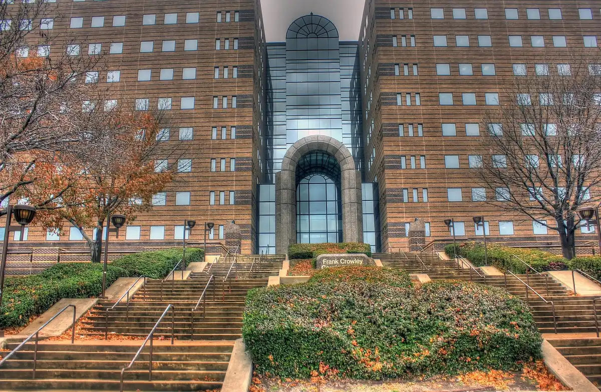 Federal courthouse entrance with marble columns and American flag, empty steps at dawn, institutional solemnity