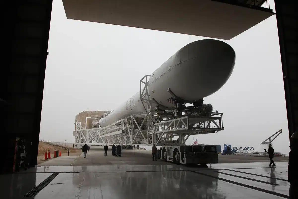 A Rocket Lab Electron rocket on the launch pad at dawn, with mission control monitors showing real-time telemetry data in the foreground, anticipation and precision evident in the technical setup