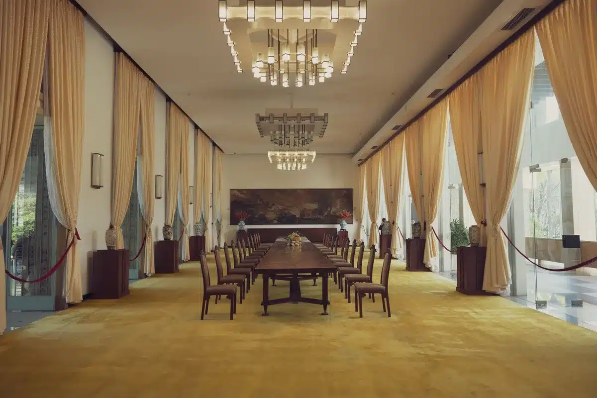 White House Roosevelt Room with empty chairs arranged for a formal meeting, soft lighting casting shadows on polished wood, a sense of anticipation and formal governance