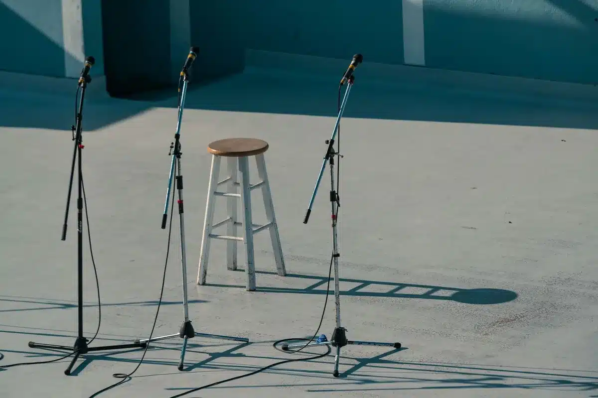 Two empty chairs facing each other across a polished conference table in dim light