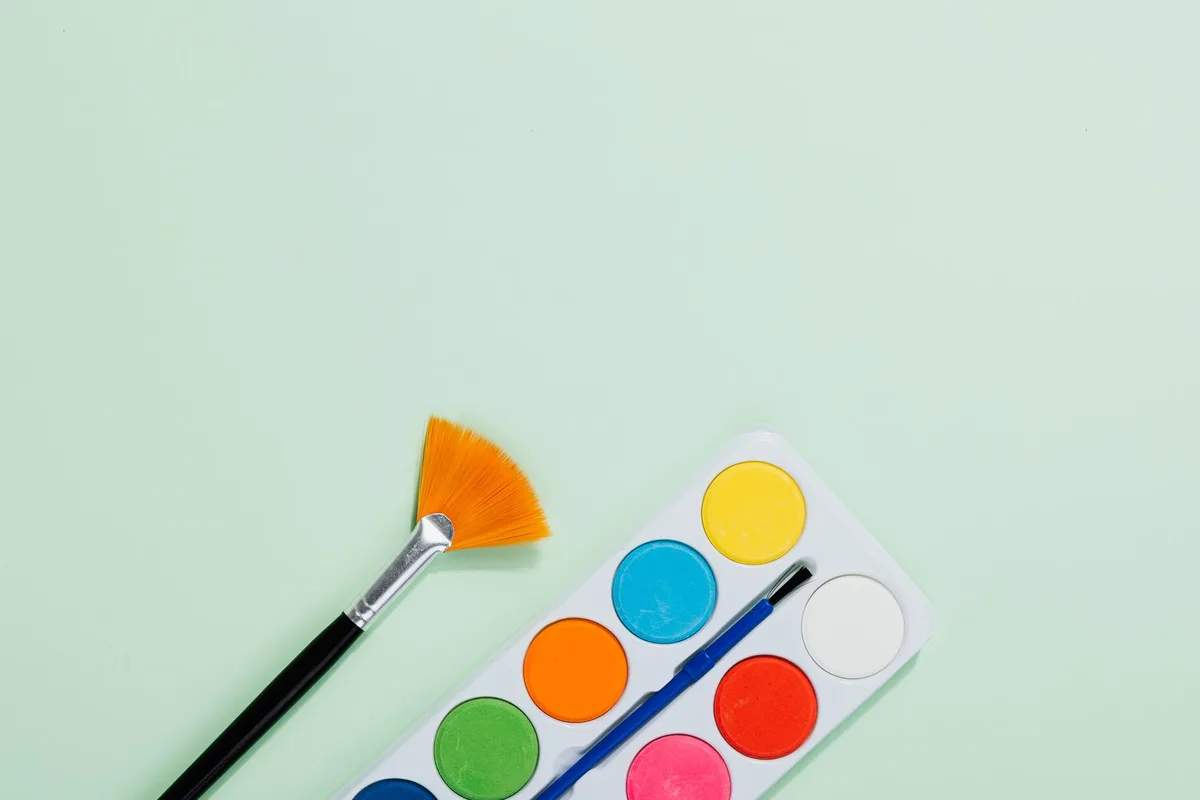 Paint color swatches arranged in warm and cool tones, layered on textured surfaces with fabric samples