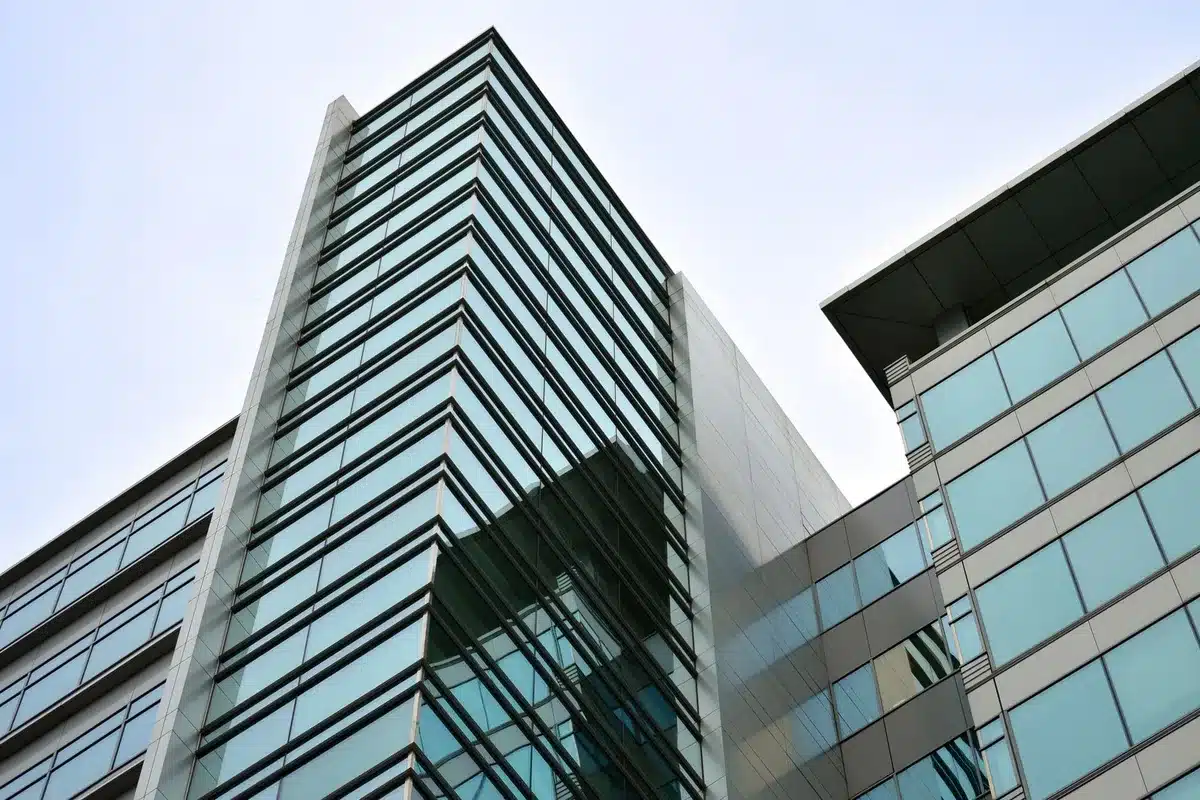 A modern office building exterior with glass and steel architecture, reflecting morning light, representing enterprise software headquarters.
